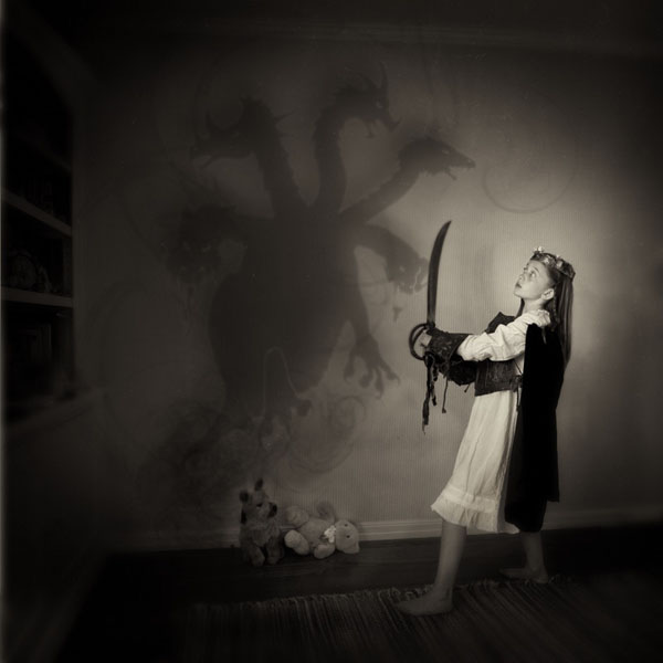 Young girl with toy sword fighting a shadow monster
