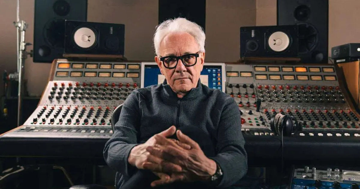 Trevor Horn sitting in front of a large recording console