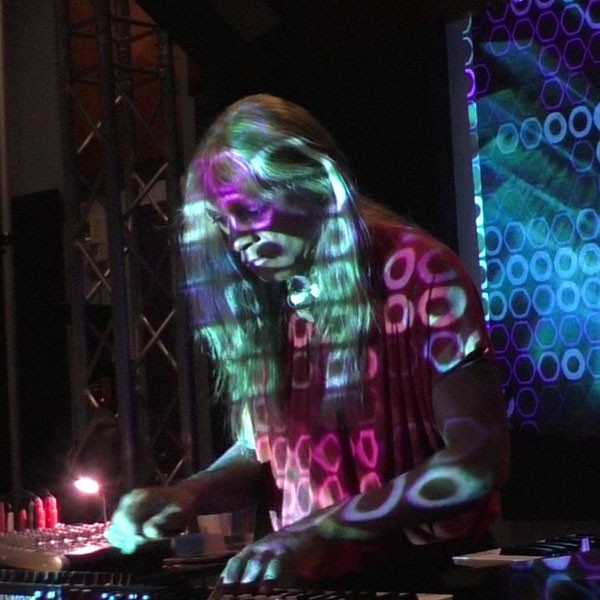 Jaymie Rose Hennegan live at synthesizers with digital light overlay circles